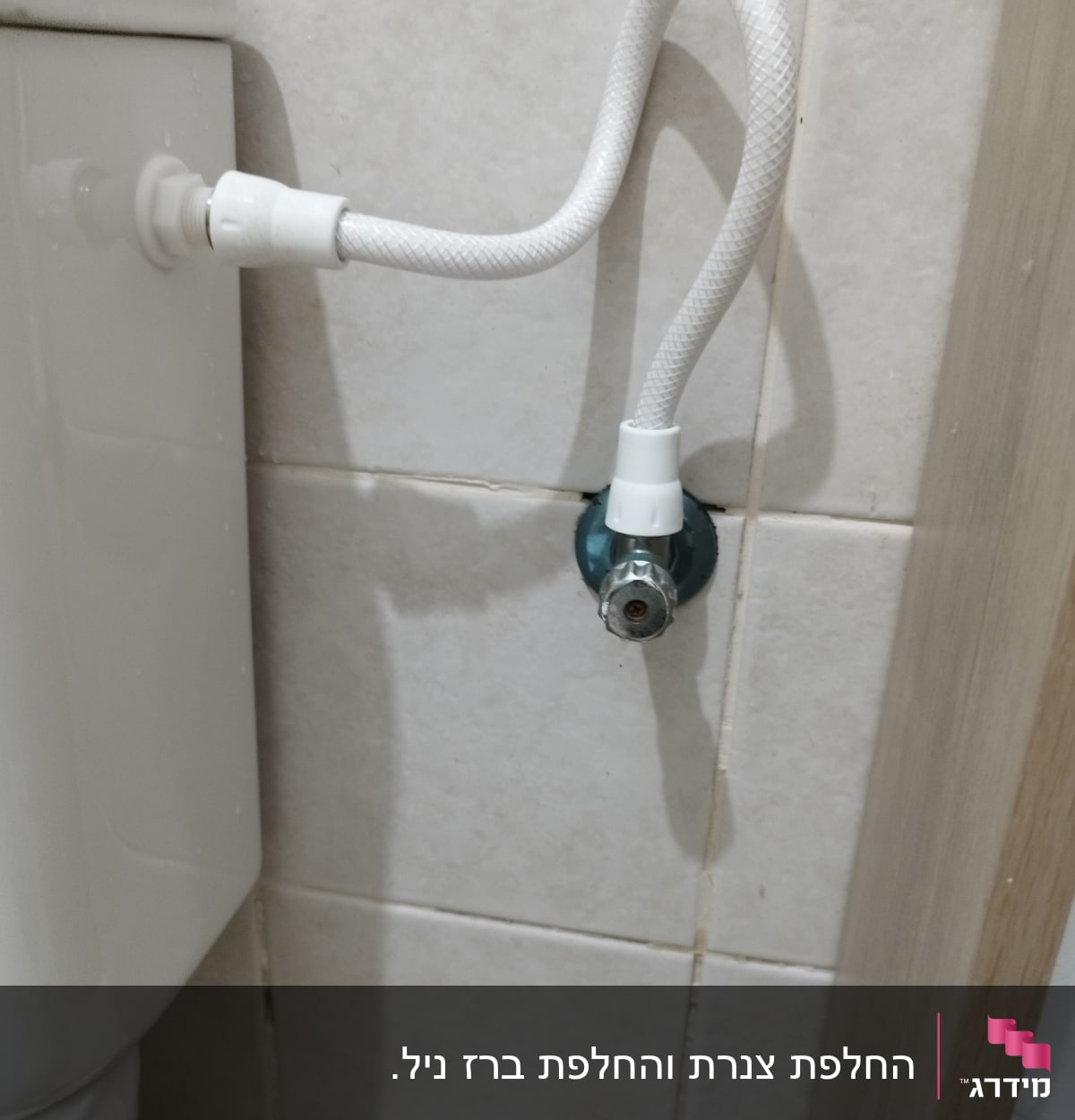 צינור מים מחובר לשירותים על קיר אריחים